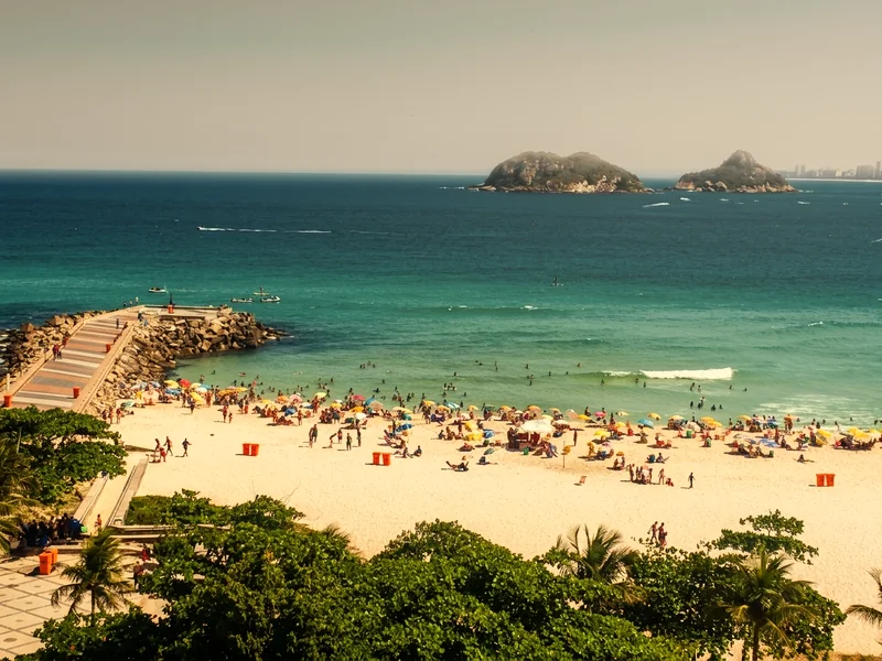 Vista do alto da Praia do Pepê, com o quebra-mar, a água turquesa e as Ilhas Tijucas